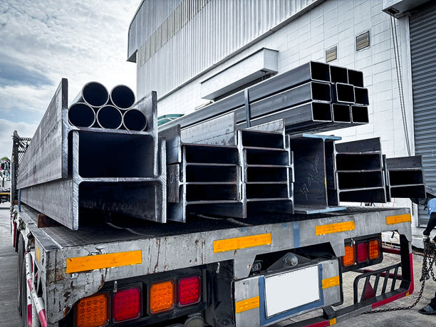 建筑工地上堆叠的钢管，黑色管道，金属管，角钢，平管，方管，特写单色照片，选择性对焦的许多管道堆叠在一起。图片下载