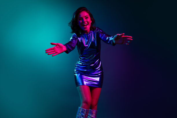 可爱的年轻女士在黑暗背景下穿着时尚的复古夜总会服装，张开双手欢迎的照片肖像图片下载