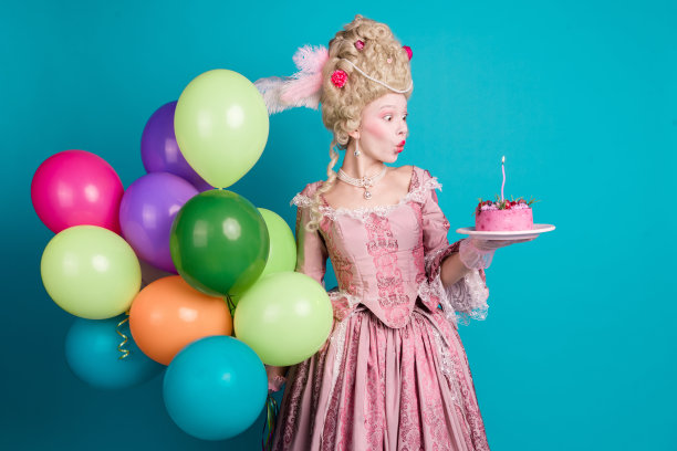 迷人的女皇身穿复古服装在蓝色背景下庆祝生日的照片图片下载
