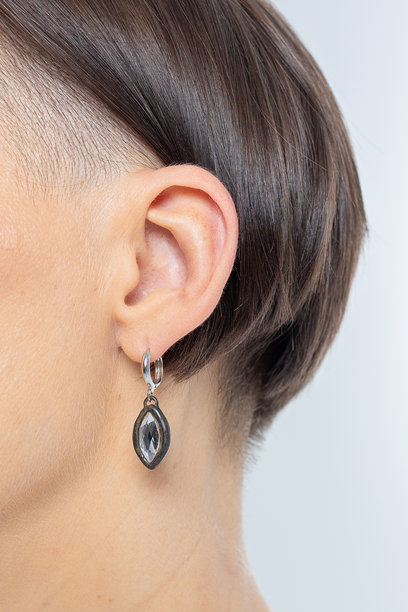 女孩耳朵上的耳环特写。美丽的女性珠宝装饰。工作室摄影。竖版照片。图片下载