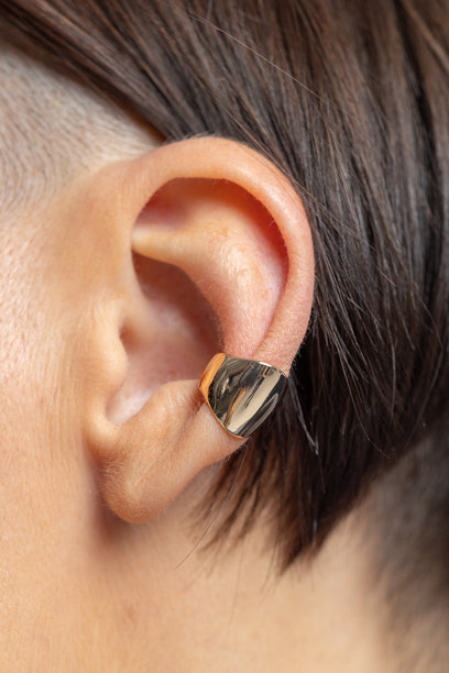 女孩耳朵上的耳环特写。美丽的女性珠宝装饰。工作室摄影。竖版照片。图片下载