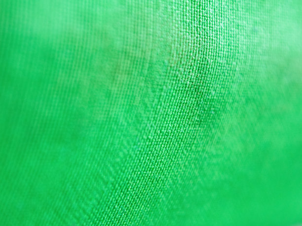 一张绿色织物的特写照片，展现出鲜艳的纹理和细节，营造出充满活力和动感的感觉，非常适合设计使用。图片下载