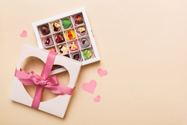 情人节构图：甜美的糖果，带有蝴蝶结的礼品盒和红色毛毡心形，照片模板，背景。俯视图，留白空间。图片下载