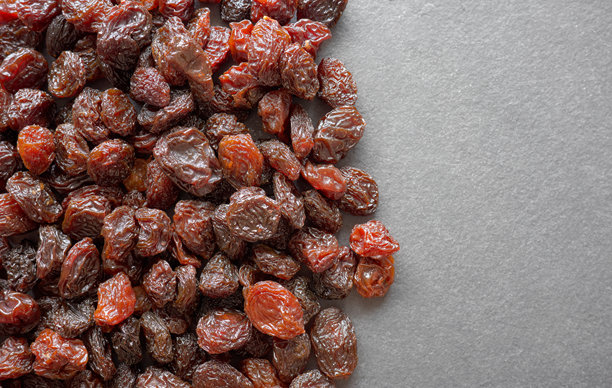 有机葡萄干的特写照片，背景为深色石板。图片下载