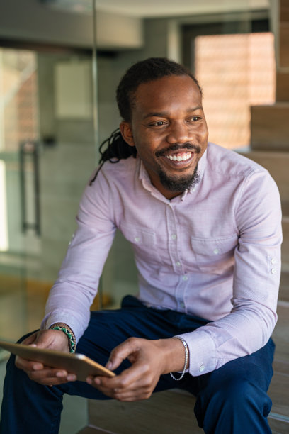成功的非裔美国商人在数字平板上阅读商业图表和股票走势图图片下载