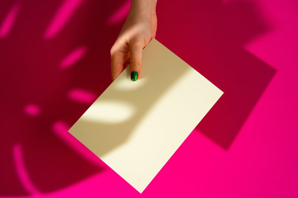 女性手握着空白名片。创意照片带有阴影效果。图片下载