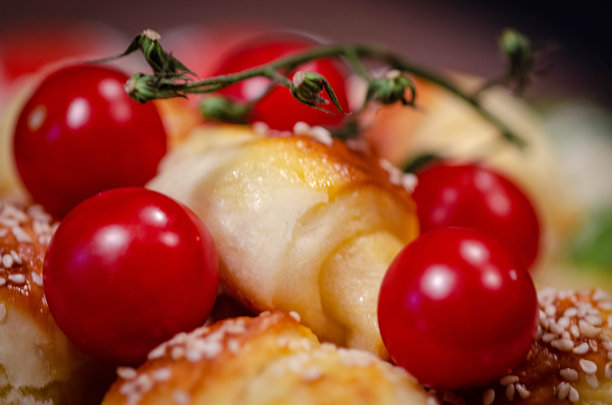 撒有芝麻的小卷饼配樱桃番茄 - 特写照片图片下载