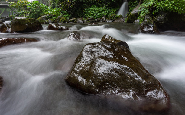 清澈的河流在山间穿过岩石，长时间曝光的照片图片下载