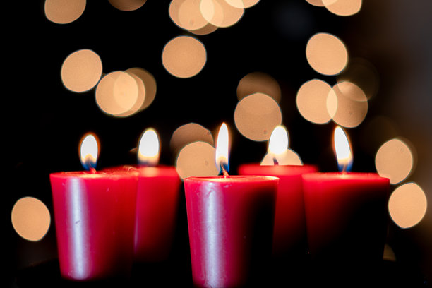 夜晚模糊圣诞树前的五支红色蜡烛特写照片图片下载