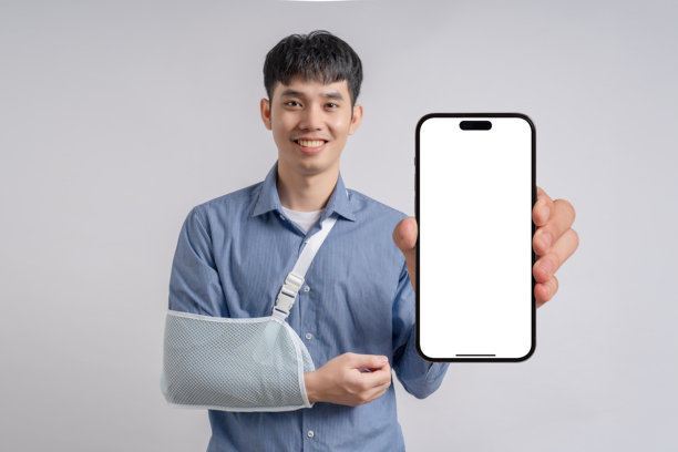 受伤手臂打着石膏的帅气商人，展示一部白色空白屏幕的智能手机。商业、金融和科技概念。高品质图片。图片下载