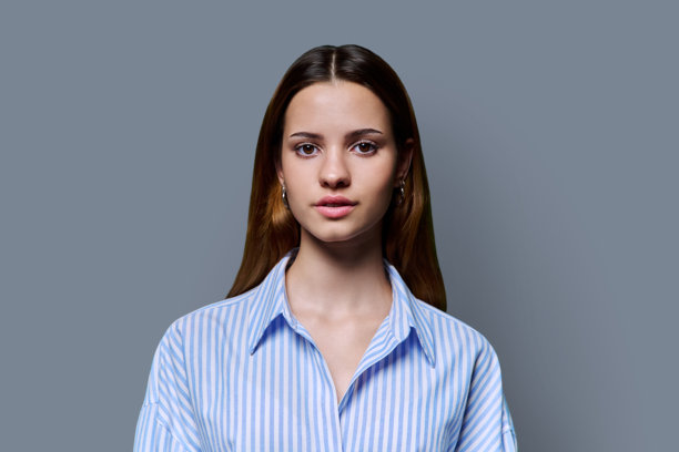 年轻严肃的红发少女的头像肖像，背景为灰色图片下载