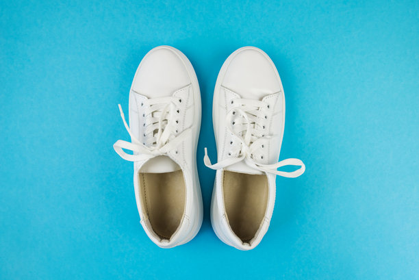 白色鞋子在孤立的淡蓝色背景上的俯视照片，周围留有空白空间。图片下载