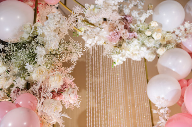 婚礼接待的拍照区，或庆祝女孩生日派对的节日区域。用粉色和白色气球、花朵装饰的拱门。照片墙装饰空间或文字展示位置。图片下载