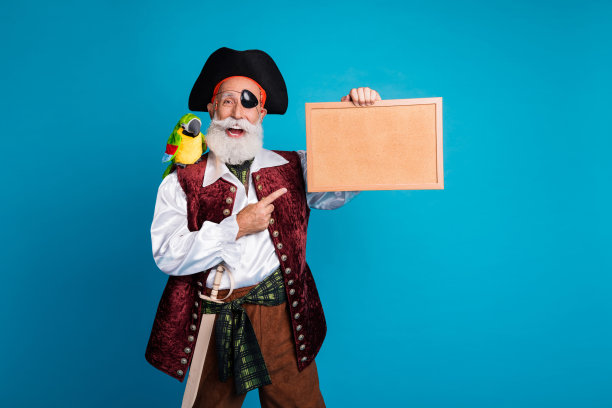 穿着万圣节服装的胡子海盗男士，手持指向画框的照片肖像，背景为蓝色。图片下载