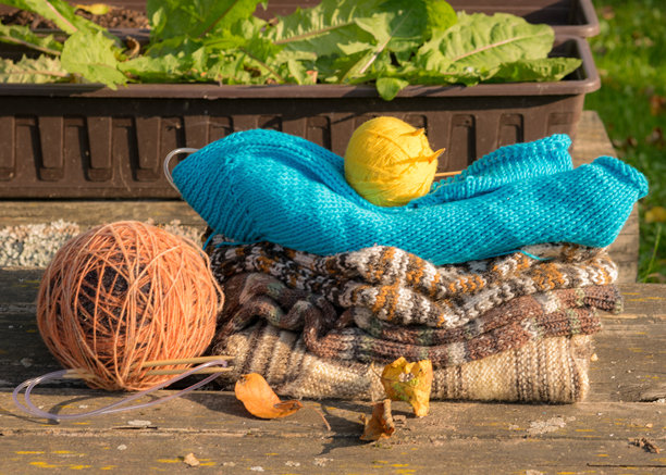 带有针织物和花朵的照片，背景为古老的木材，质感优美，背景模糊，秋季气息。图片下载