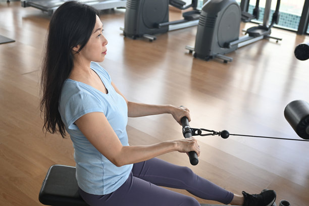 亚洲女性在划船机上锻炼的照片图片下载