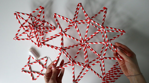 女性的手握着一颗星星。白色背景上有其他星星。照片。家居装饰创意。图片下载