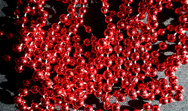 黑色背景上的红色闪亮珠子照片。部分模糊。微距。图片下载