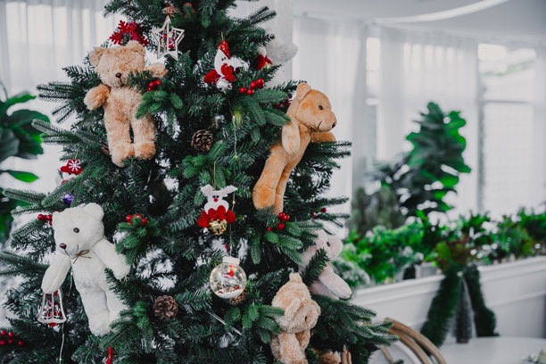 圣诞快乐，色彩缤纷的球体、礼品盒和圣诞祝福图片包裹，铃铛装饰在绿色圣诞树背景下，圣诞和新年期间的装饰。图片下载