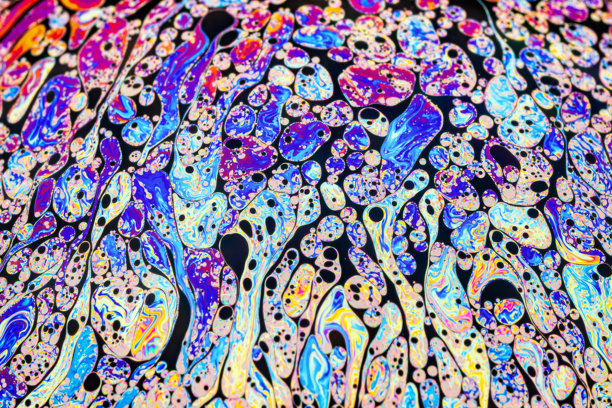 真实照片展示了肥皂泡表面上色彩斑斓的光干涉效果，伴有随机的涡旋、曲线和线条。图片下载