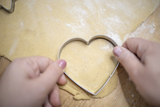 揉面团和制作姜饼饼干的特写照片，适合圣诞节。图片下载