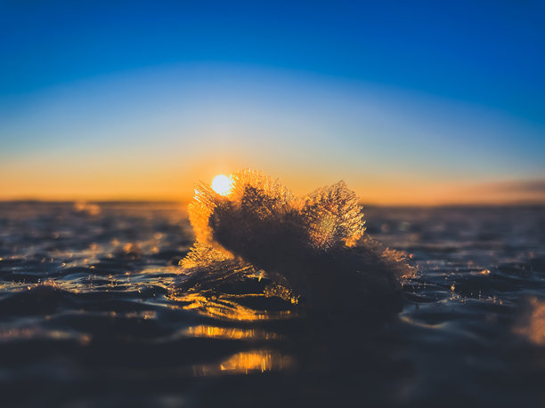 寒冷的空气和冰冻的湖面在美丽的日落景观中。美丽的冰形状和阳光。照片来自芬兰索特卡莫。图片下载