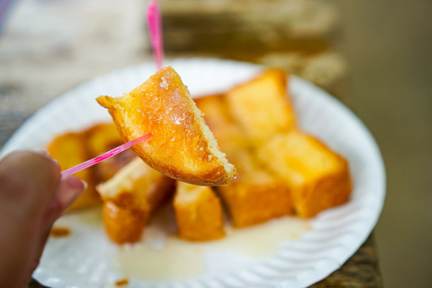 早餐开胃菜：木质餐桌上的黄油、牛奶、糖搭配面包棒的特写照片，素食食品。图片下载