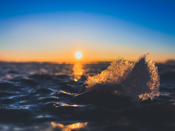 寒冷的空气和冰冻的湖面在美丽的日落景观中。美丽的冰形状和阳光。照片来自芬兰索特卡莫。图片下载