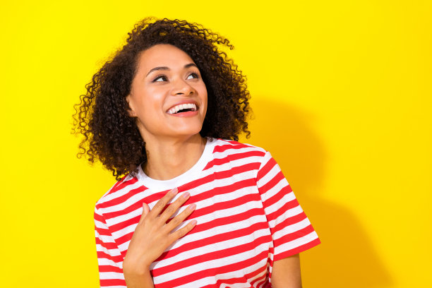 年轻有趣的女人在黄色背景下大笑，目光投向空旷的地方，特写照片。图片下载