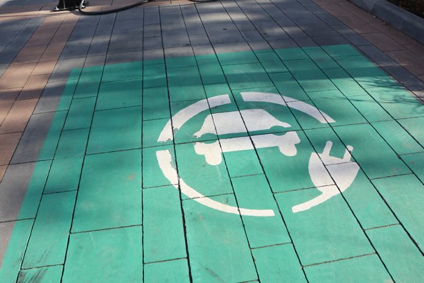 这张图片展示了电动车充电站标志在路面上的标记。图片下载