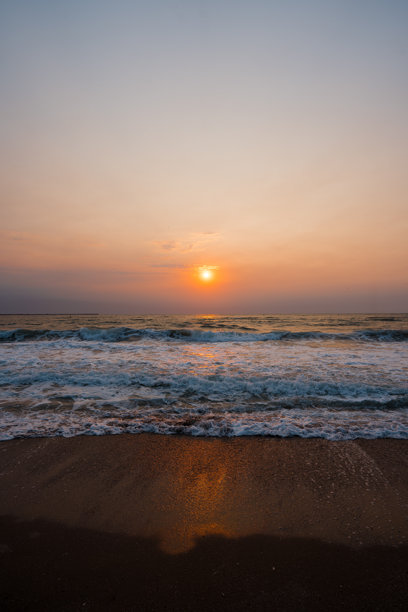 一张令人惊叹的照片，展示了罗马尼亚埃福里耶黑海上的日出，温柔的海浪轻轻拍打着海岸。图片下载
