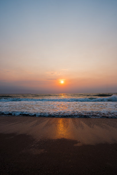 一张令人惊叹的照片，展示了罗马尼亚埃福里耶黑海上的日出，温柔的海浪轻轻拍打着海岸。图片下载