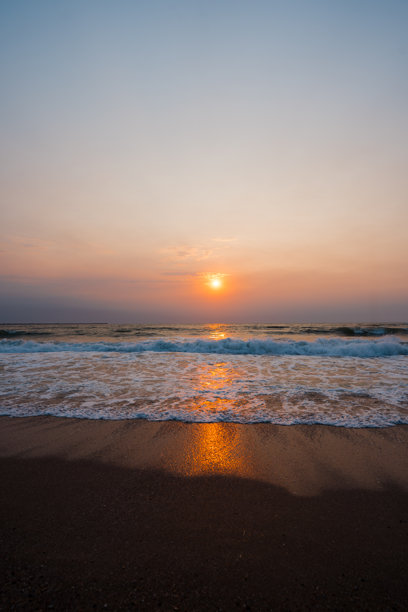 一张令人惊叹的照片，展示了罗马尼亚埃福里耶黑海上的日出，温柔的海浪轻轻拍打着海岸。图片下载