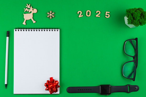 一张白色钞票上有一个黑色弹簧，空白钞票的右下角有一个红色礼品蝴蝶结，左侧放着一支白色铅笔，铅芯和橡皮都是黑色，照片的背景是绿色的色键，上面放着一盆绿色办公植物。图片下载