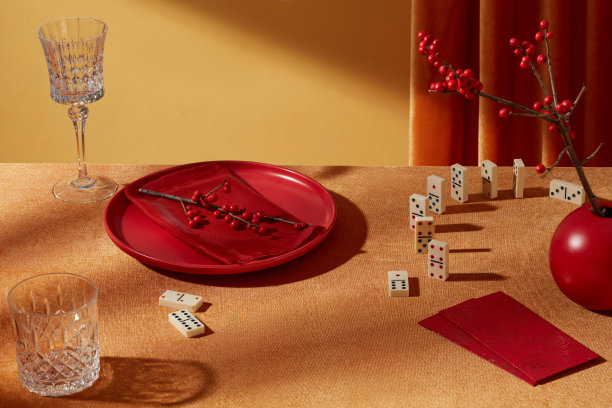 春节概念照片用于设计宣传图，采用高角度拍摄。黄色桌子上为新年准备的红色菜肴、酒杯、红包和花瓶散落排列。图片下载