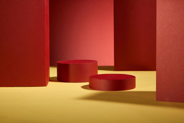 正面视角的广告背景照片，红色和黄色色调。中央有两个红色圆形展台用于产品展示，红色墙面装饰。图片下载