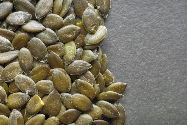 有机南瓜籽的特写照片，背景为深色石板。图片下载