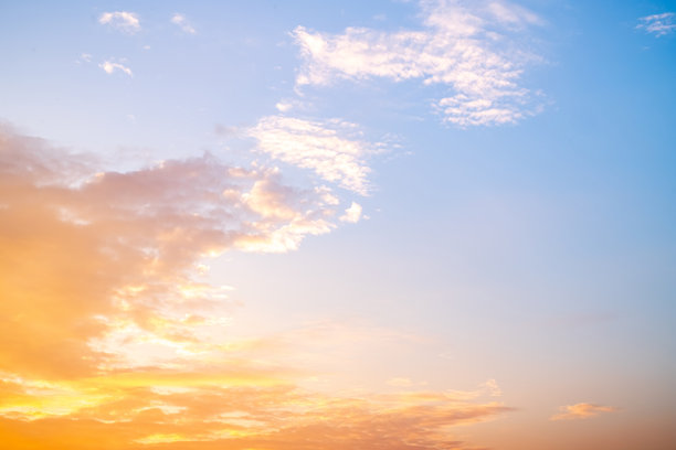 美丽奢华的柔和渐变橙金色云彩和阳光映衬在蓝天上，完美适合作为背景，拍摄于黄昏时分，清晨，超大尺寸，高分辨率的风景照片图片下载