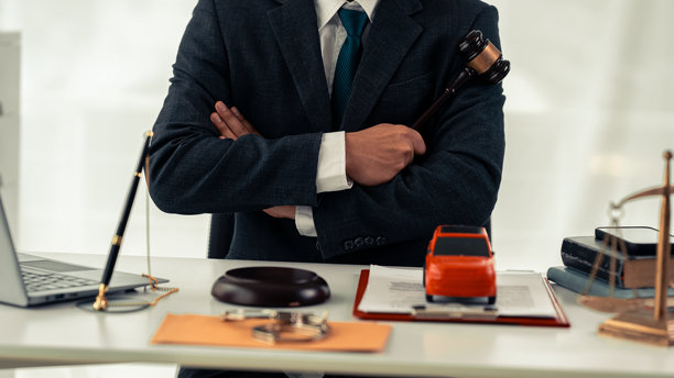 一辆玩具车与一个人手持法官锤，简单的买卖汽车，机器扣押审判，所有权确认，特写照片图片下载