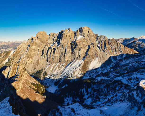 在瑞士阿尔卑斯山徒步旅行。在格拉鲁斯的弗罗纳尔普斯托克山攀登。美丽的秋季氛围，阴凉的山坡上覆盖着雪。瑞士的旅行渴望。高质量照片。图片下载