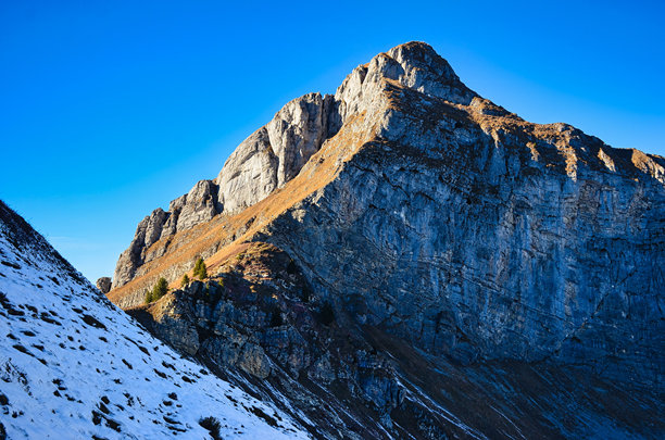 在瑞士阿尔卑斯山徒步旅行。在格拉鲁斯的弗罗纳尔普斯托克山攀登。美丽的秋季氛围，阴凉的山坡上覆盖着雪。瑞士的旅行渴望。高质量照片。图片下载