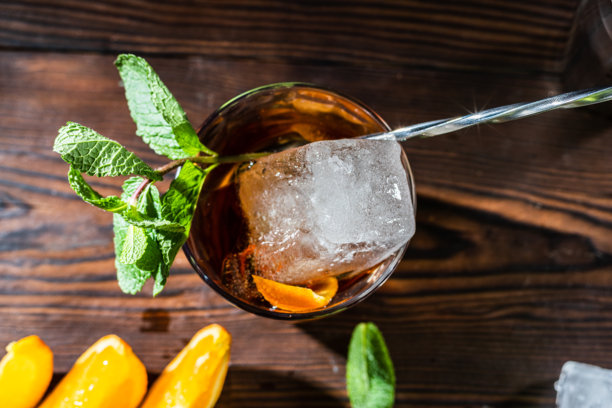 玻璃杯中的冰块特写照片。鸡尾酒的俯视图。调酒师的勺子和鸡尾酒中的冰块。图片下载