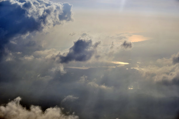 飞机上俯瞰城市景观，云层覆盖的蓝天，照片可能有一些噪点。图片下载