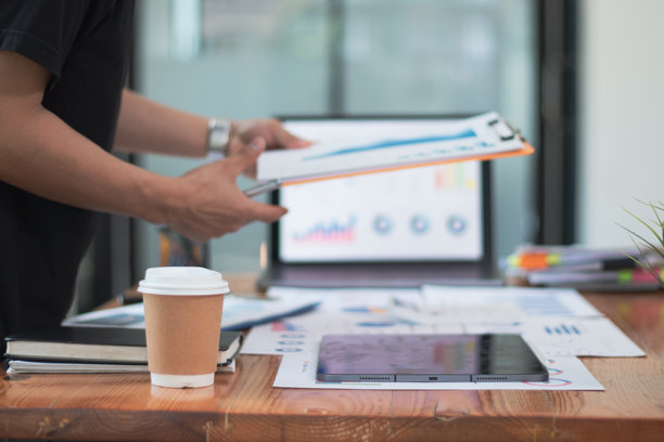 商人的桌子上摆满了女友的照片、咖啡杯、笔记本电脑和计算器图片下载