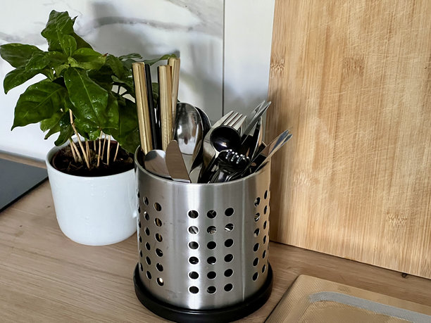 横向照片，展示了一个切菜板、一个放置餐具的杯垫和一个盆栽植物。图片下载