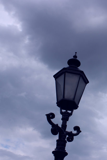 黑色金属柱子与装饰性街灯在阴云密布的天空下的垂直库存图片图片下载