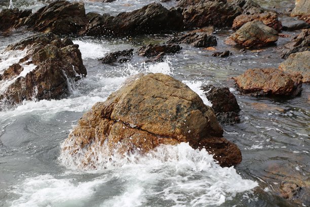 海岸上的岩石，水花溅落在上面，特写照片图片下载