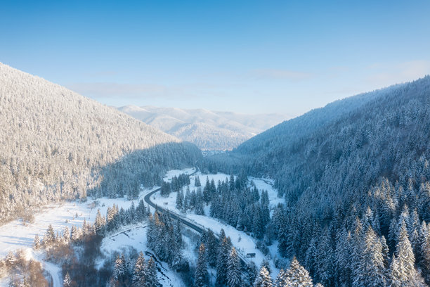 山谷。无人机拍摄的场景。被雪覆盖的森林。自然冬季景观的空中视角。无人机拍摄的风景。适合明信片、背景和壁纸的照片。图片下载