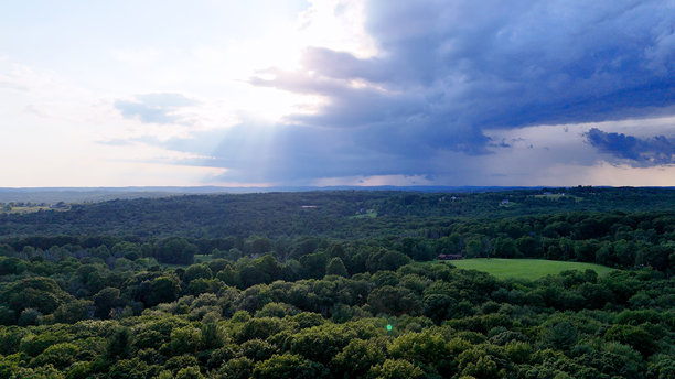 风暴和阴暗的无人机航拍照片，展示了康涅狄格州的乡村森林、农田和大量林地。这是一个非城市的乡村地区。图片下载