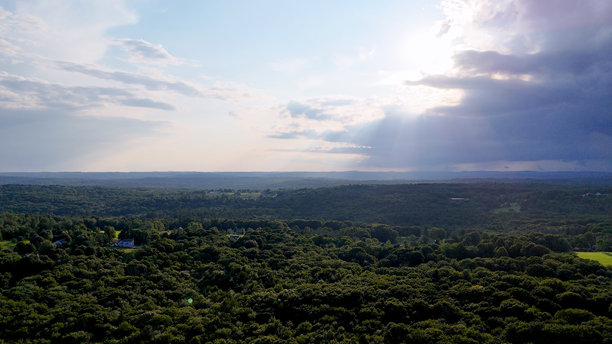 风暴和阴暗的无人机航拍照片，展示了康涅狄格州的乡村森林、农田和大量林地。这是一个非城市的乡村地区。图片下载